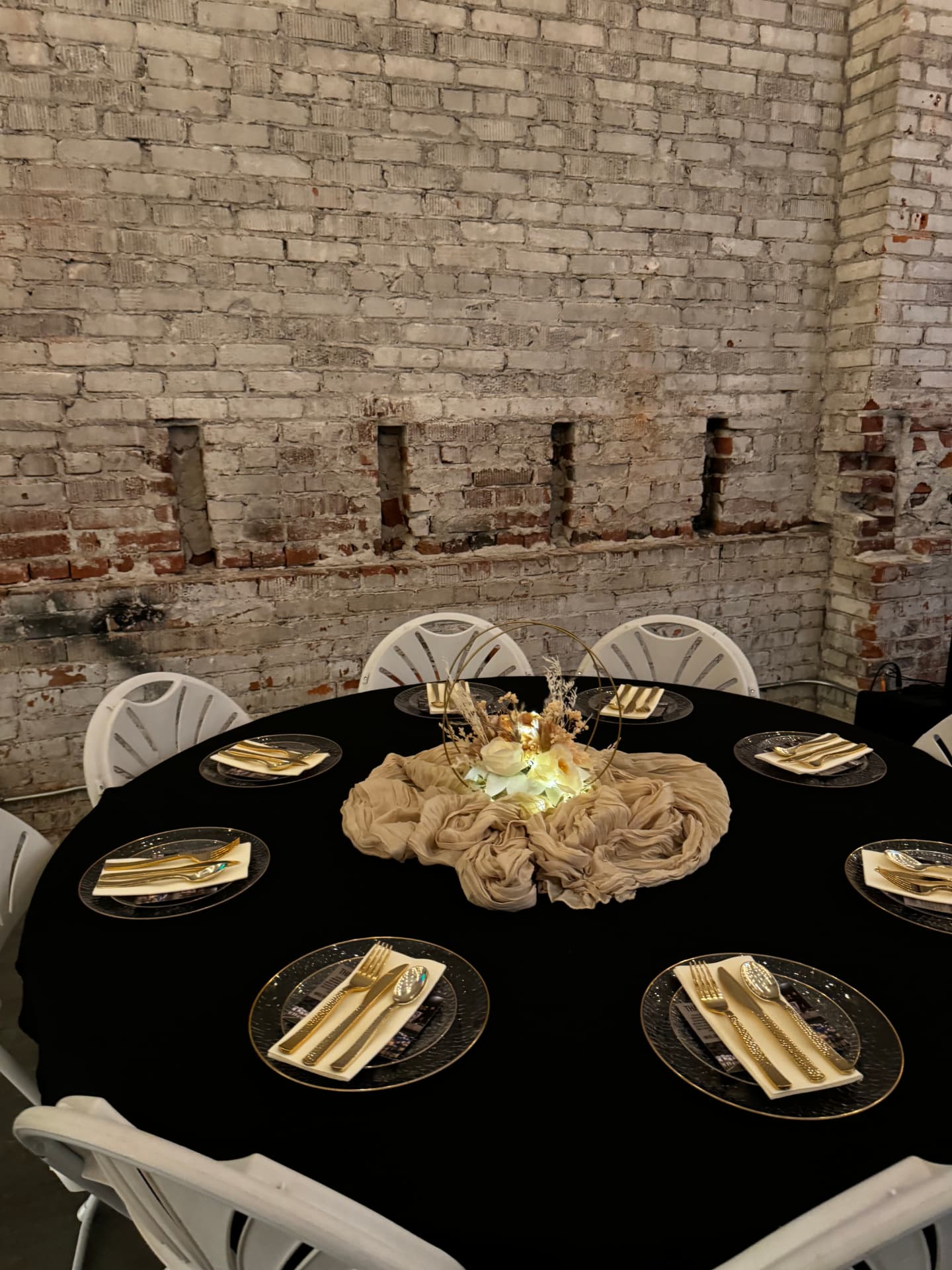 Black and gold table setting with gold flatware at Host Wenatchee