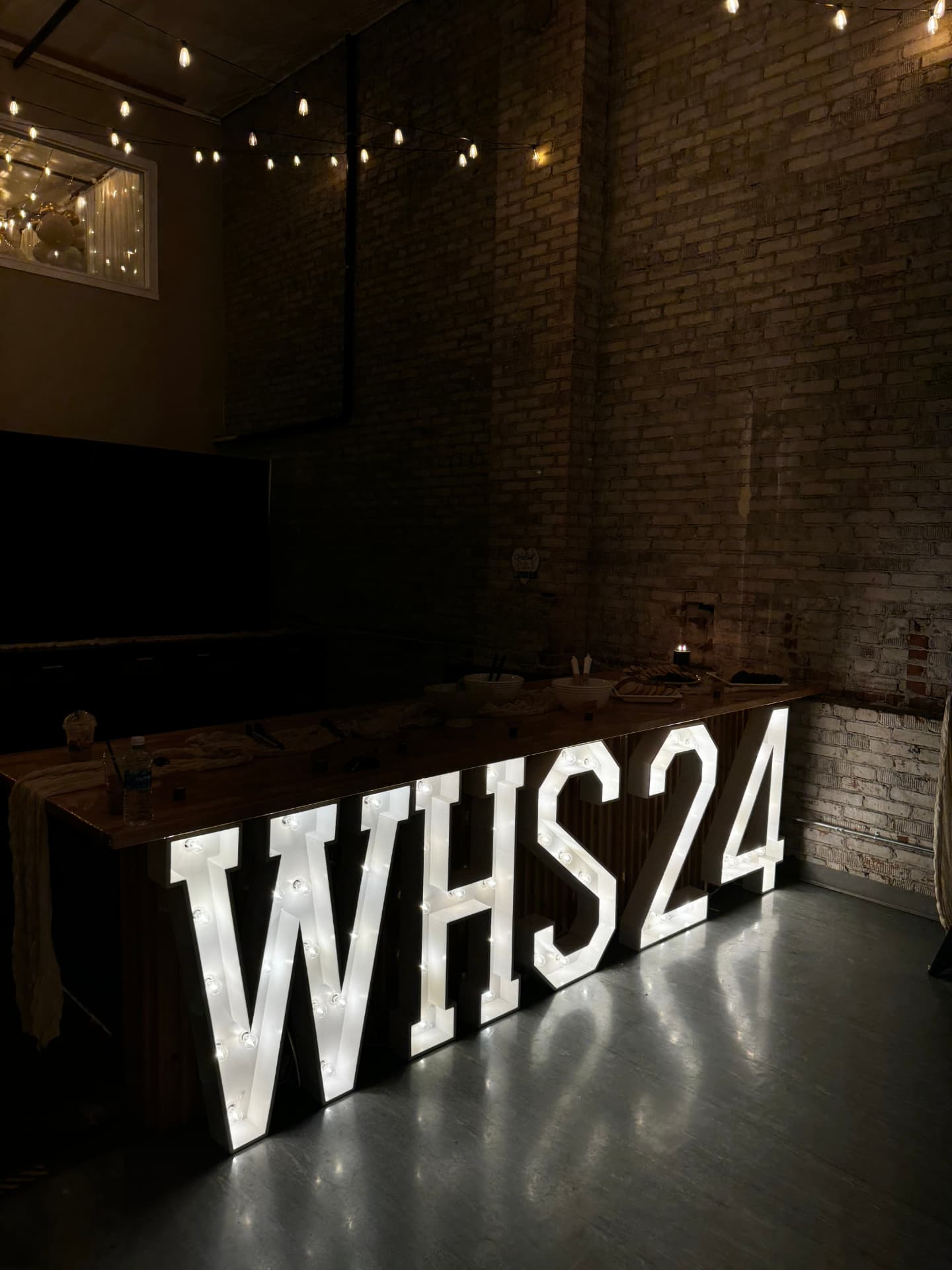 Glowing marquee letters against the exposed brick wall at Host Wenatchee