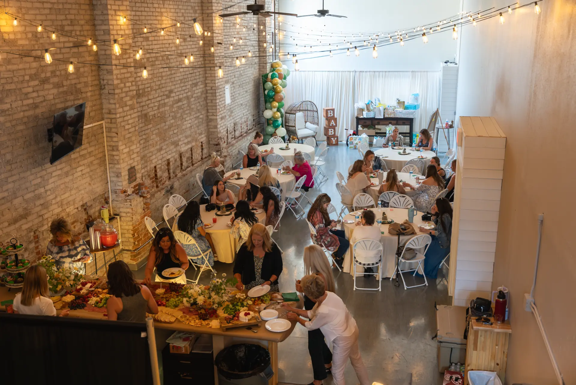 Baby shower with grazing table, string lights and round guest tables at Host Wenatchee