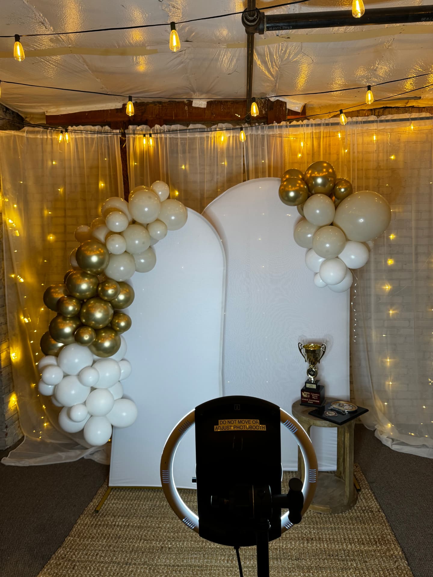 Photo booth with white arch backdrop and balloon garland at Host Wenatchee