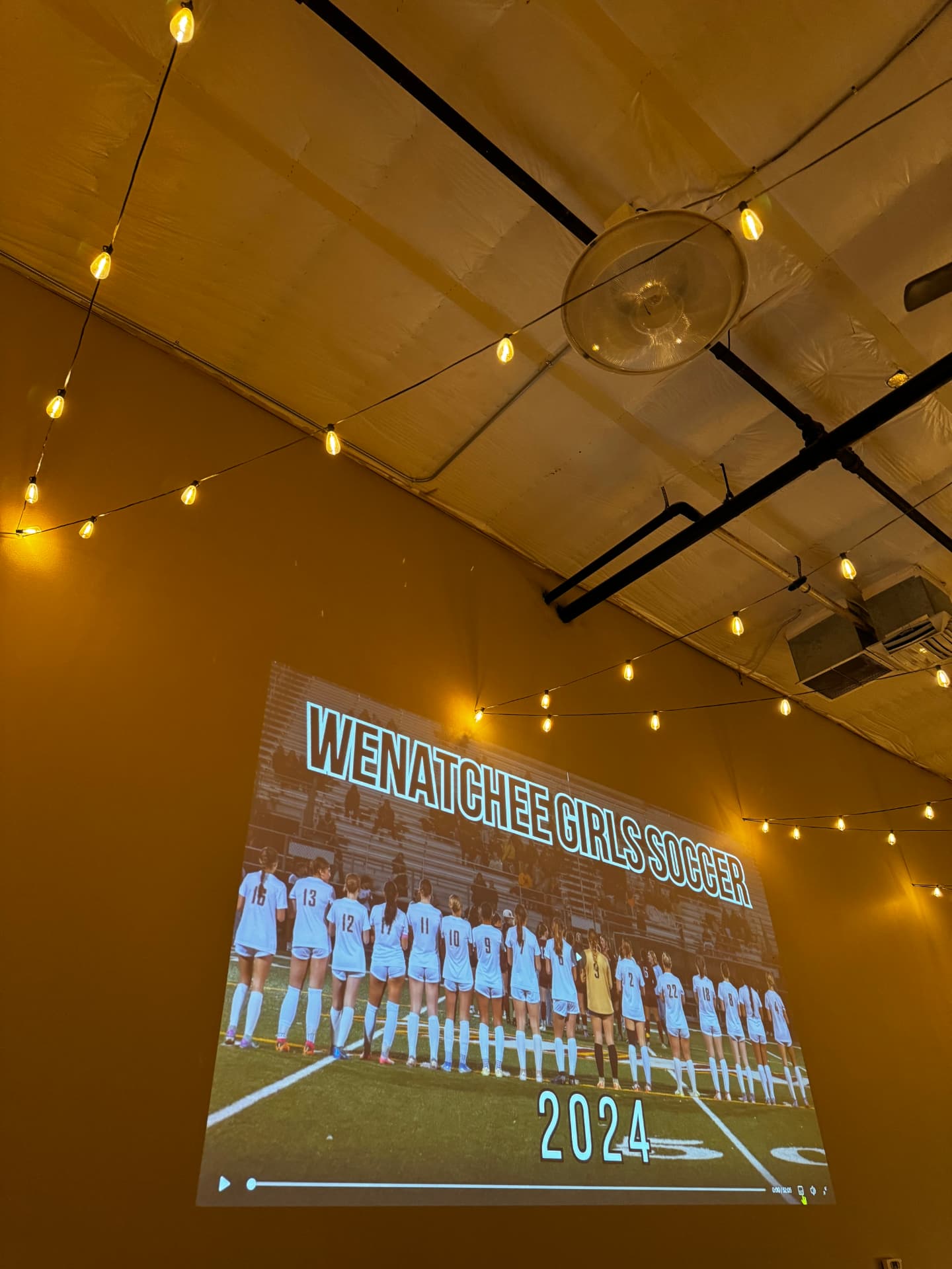 Projector slideshow on the wall during a banquet at Host Wenatchee