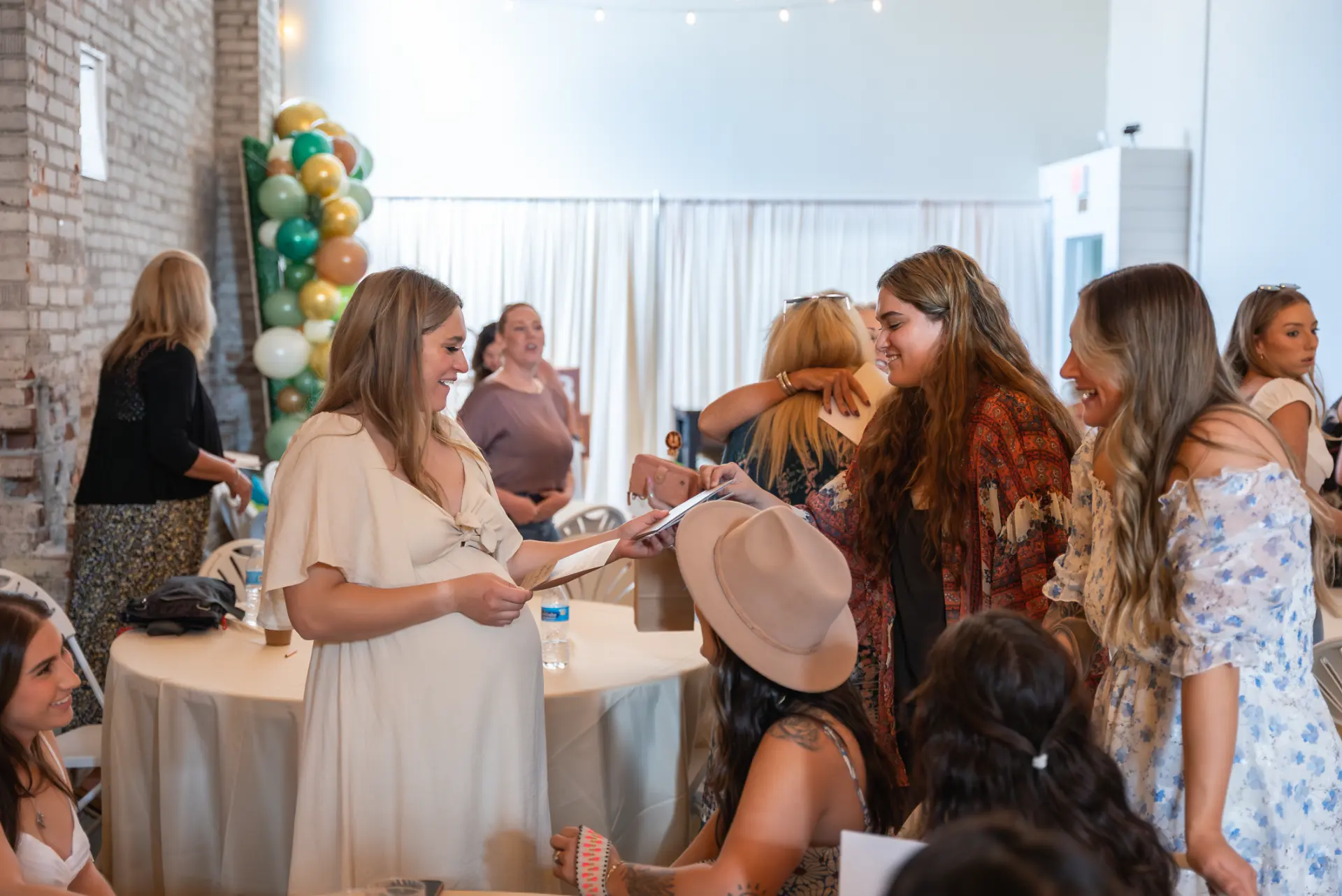 Guest of honor opening gifts at a baby shower at Host Wenatchee